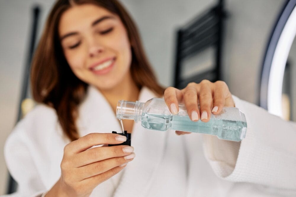 Young woman pouring mouth wash