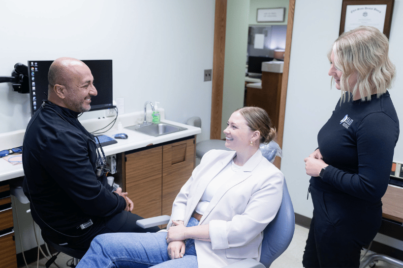 Dentist and assistant with smiling patient during dental checkup